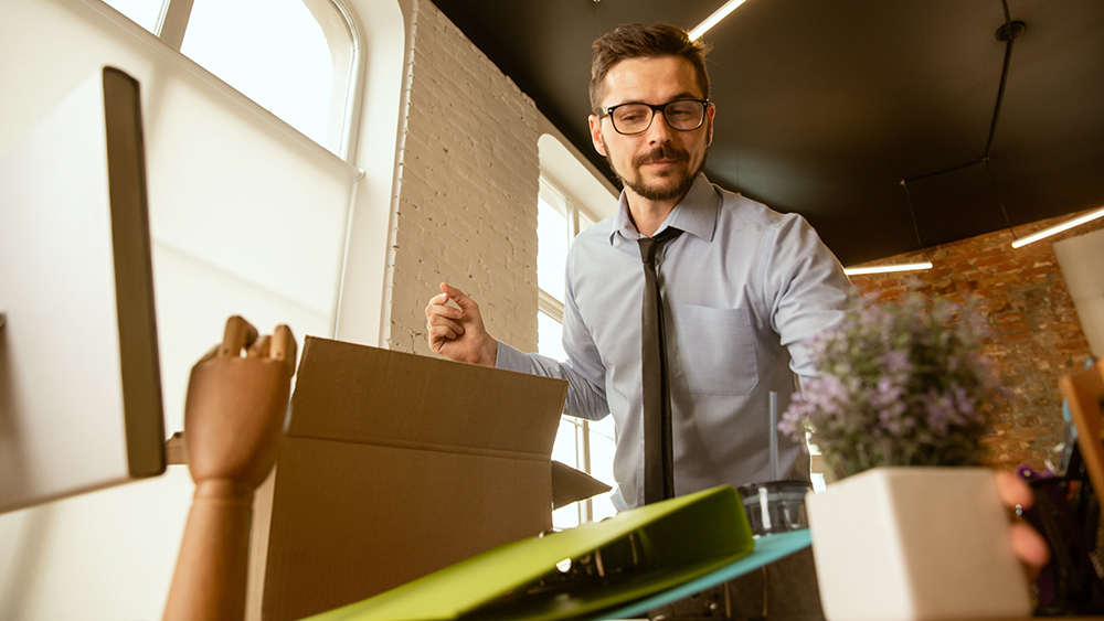 A man puts office stuff into boxes for moving